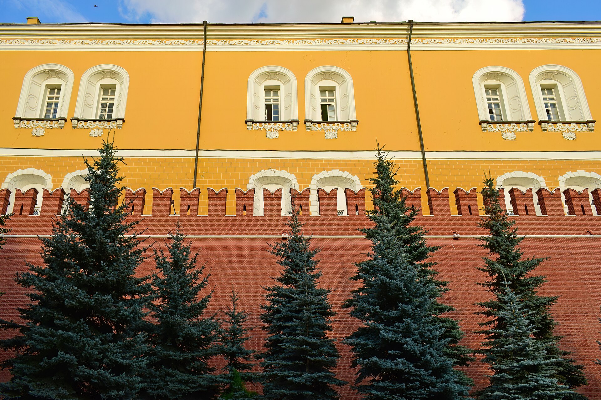La muralla roja del Kremlin vista desde los Jardines de Alejandro, con césped y árboles